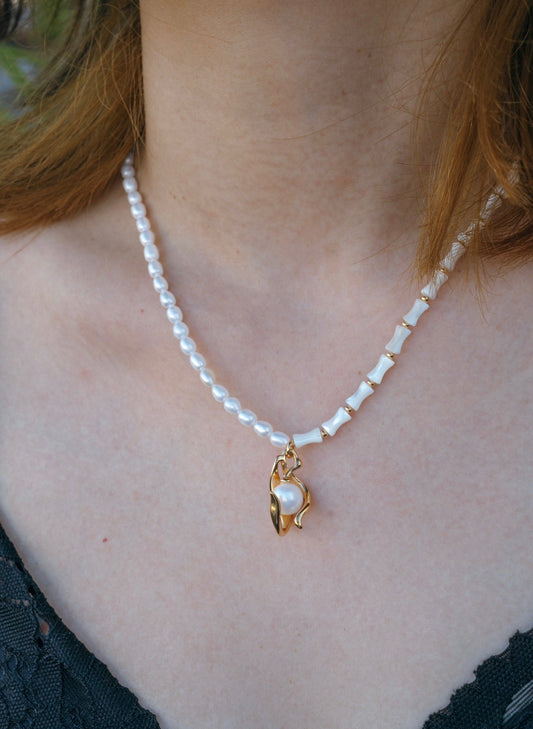 Bamboo Symphony Necklace, a true masterpiece of grace and elegance. Crafted with love, this necklace features a beautiful Bamboo Knot design adorned with a lustrous pearl.